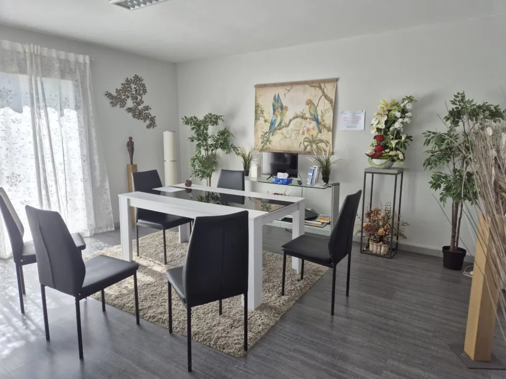 Salle d'accueil des familles et de conseil en pompes funèbres décorée avec chaises noires