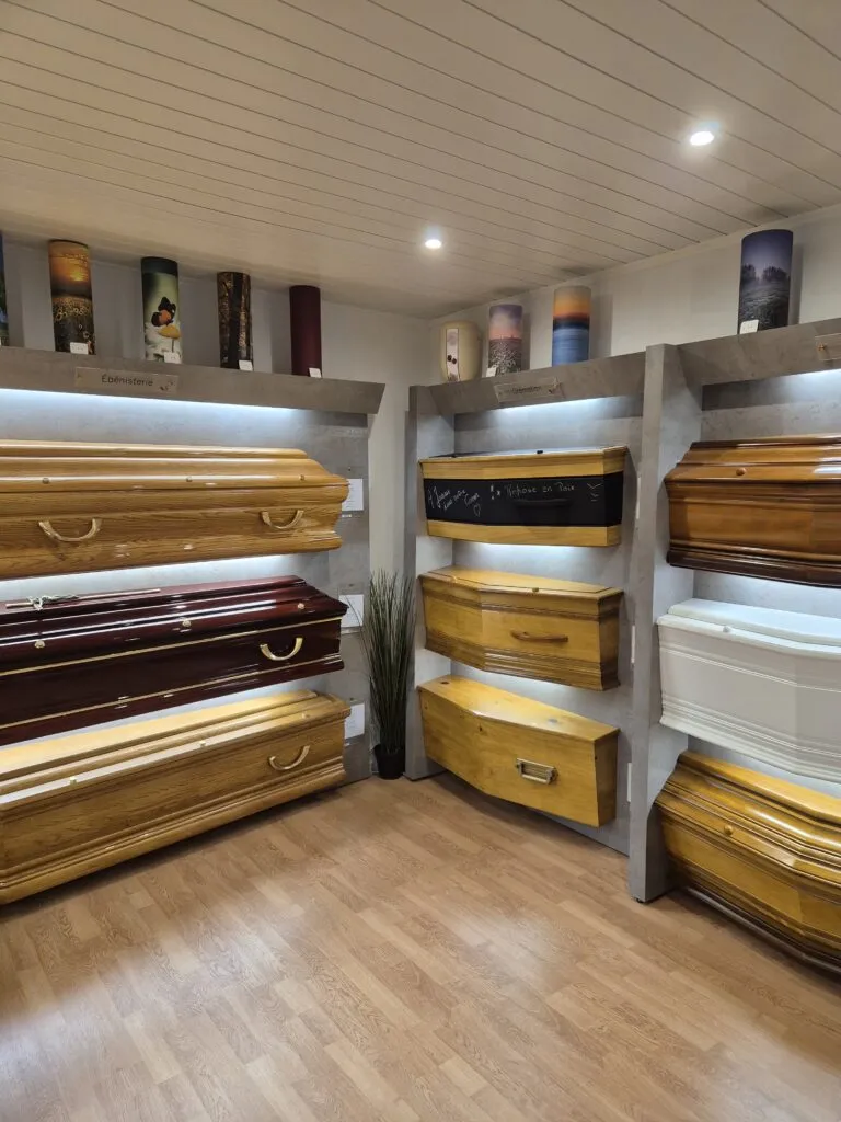 Exposition de cercueils en bois massif et teinté dans le showroom de l'agence funéraire
