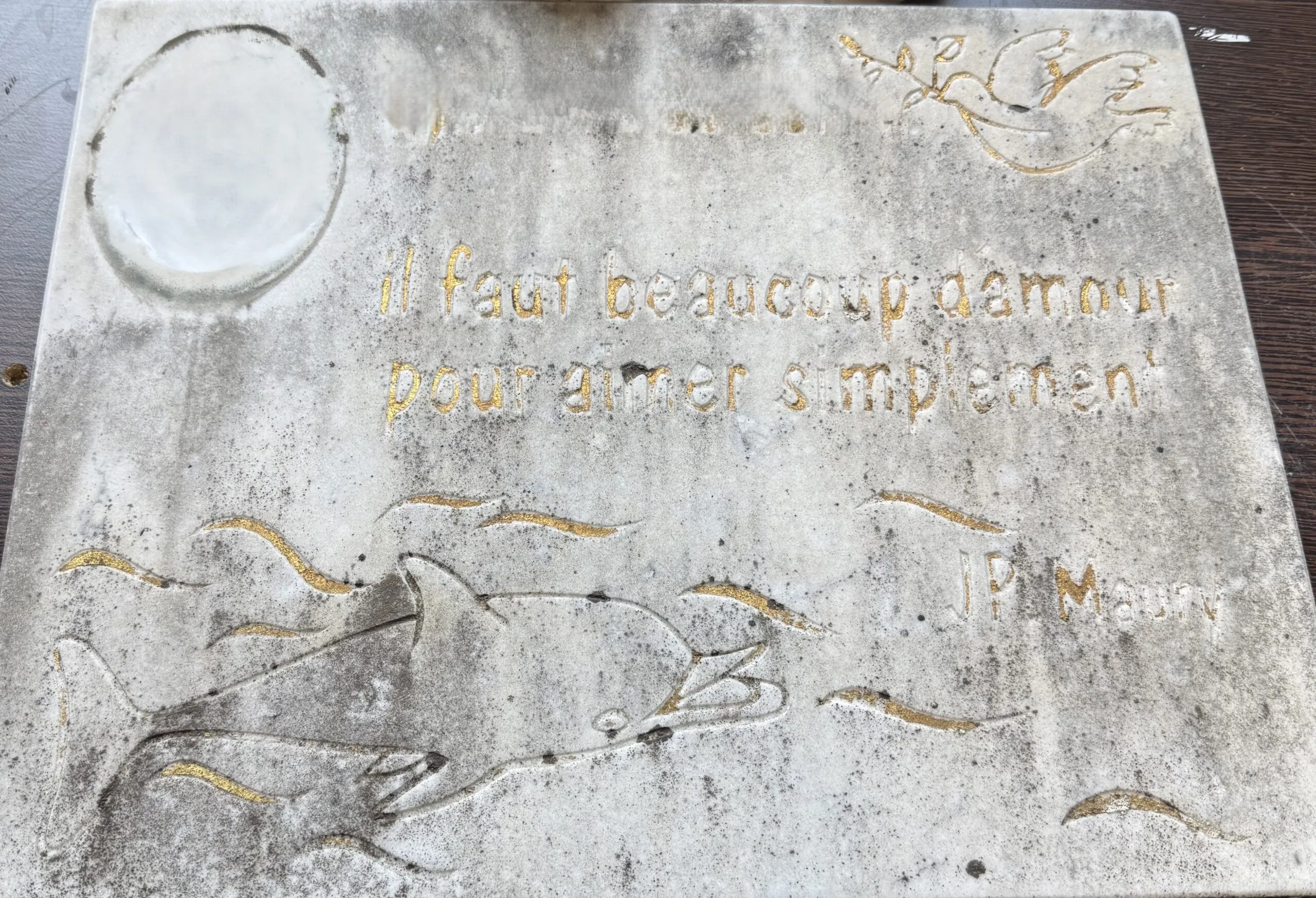 Plaque funéraire en marbre blanc usée et encrassée par le temps avant restauration