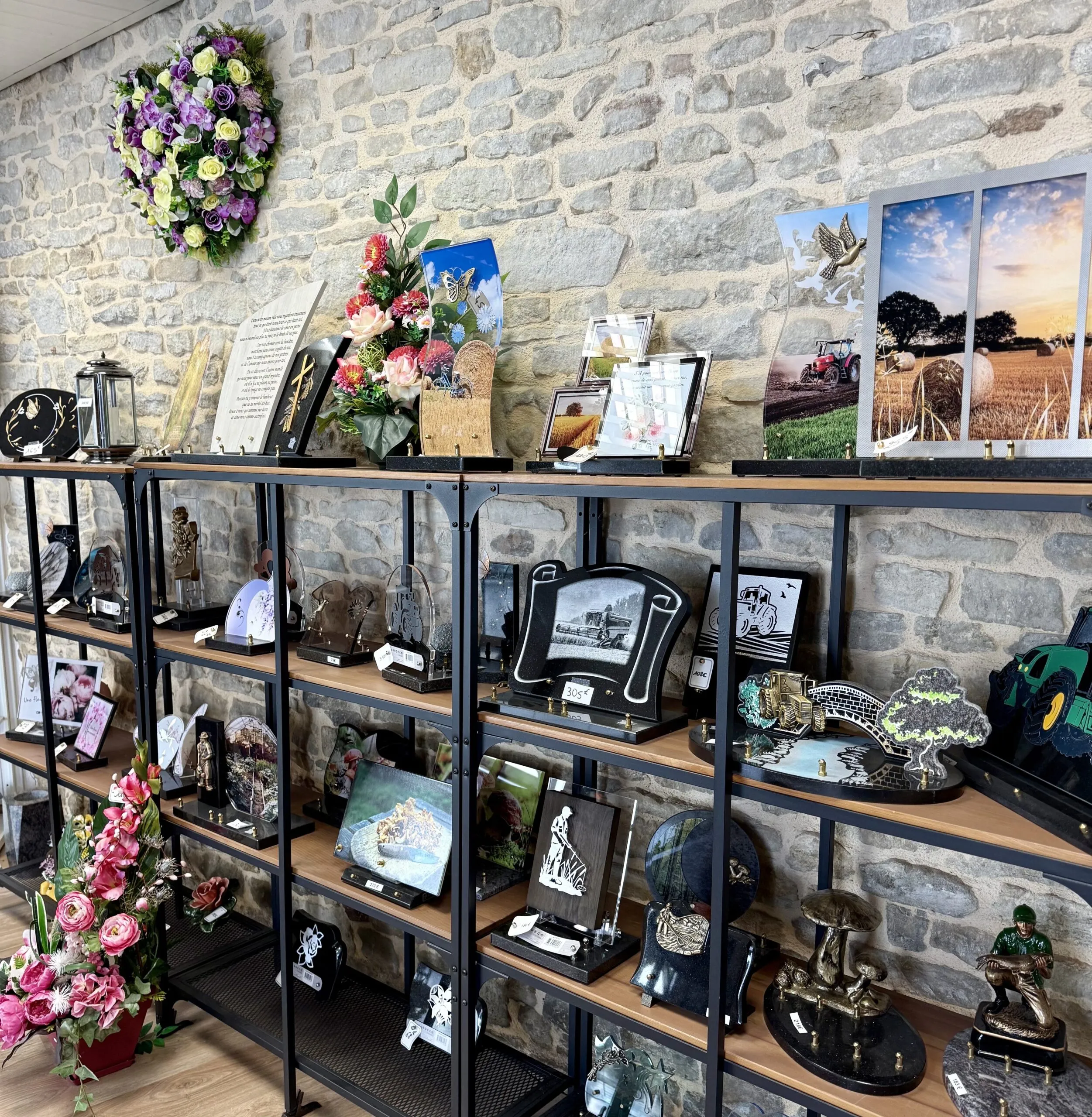 Présentation de plaques funéraires personnalisées et compositions florales sur étagères