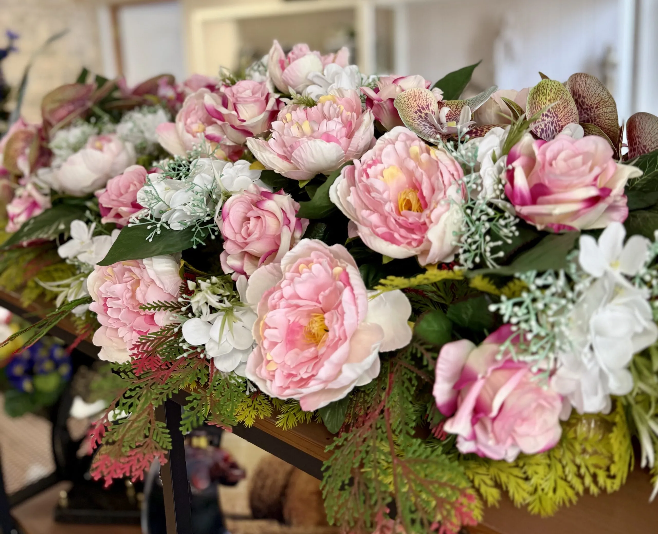 Gros plan sur une composition florale funéraire de pivoines et roses roses et blanches