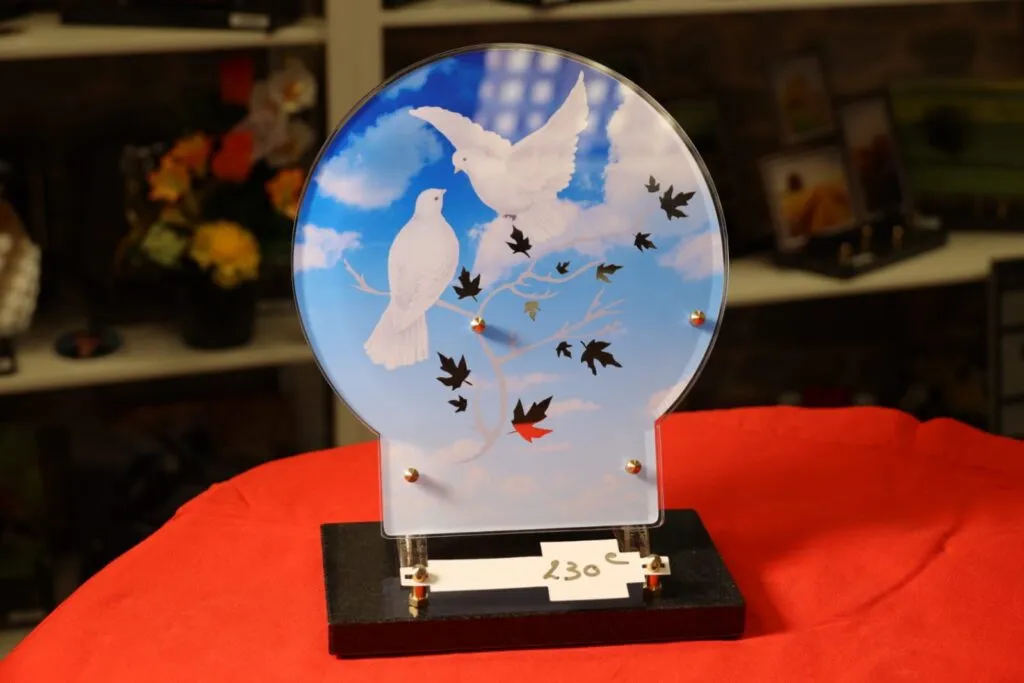 Plaque funéraire circulaire avec motif de colombes volant dans un ciel bleu